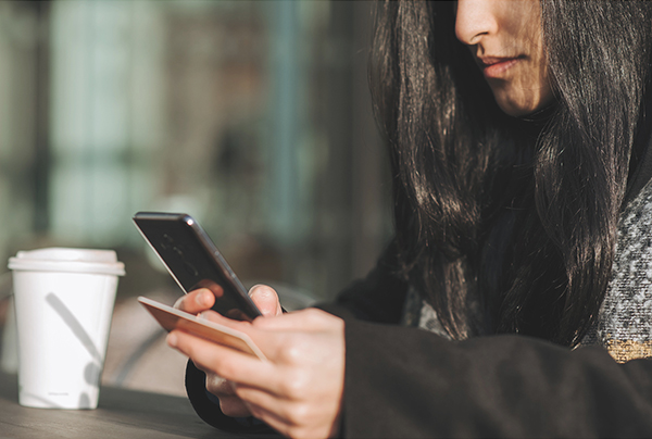 woman with coffee on phone